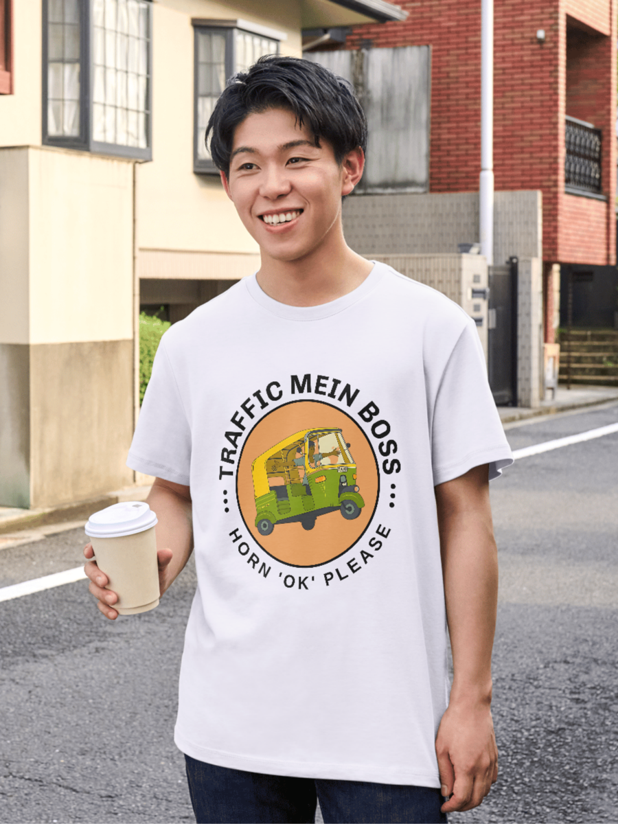 Person wearing a white t-shirt with a graphic design and text, standing on a street.